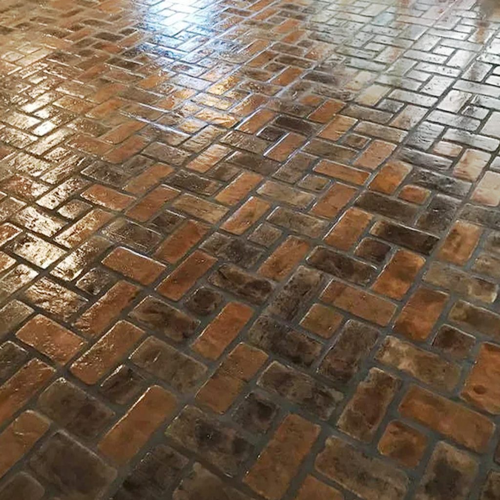 Pinwheel pattern on a floor in the Abbeville brick color. 