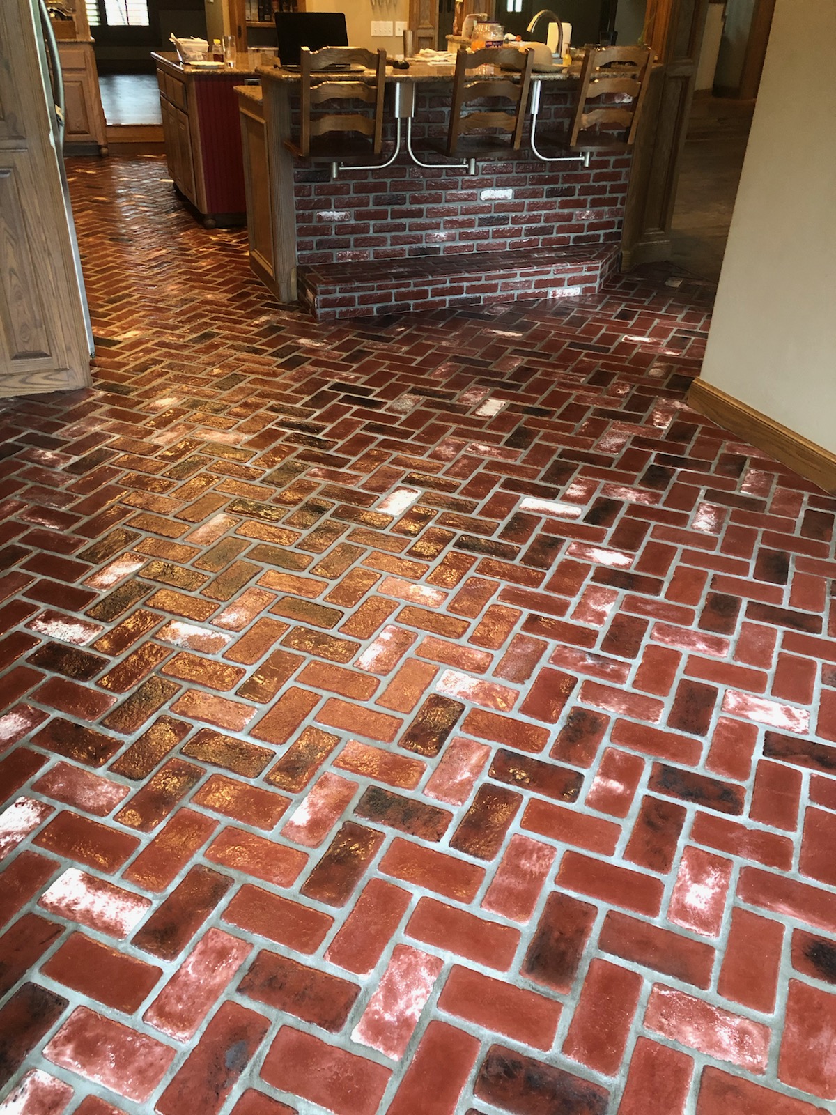 Patriot Pavers thin brick veneer. Brick floor in a kitchen. Sadie's Vineyard brick color.  Alpha Brick Antique Burgundy brick color.